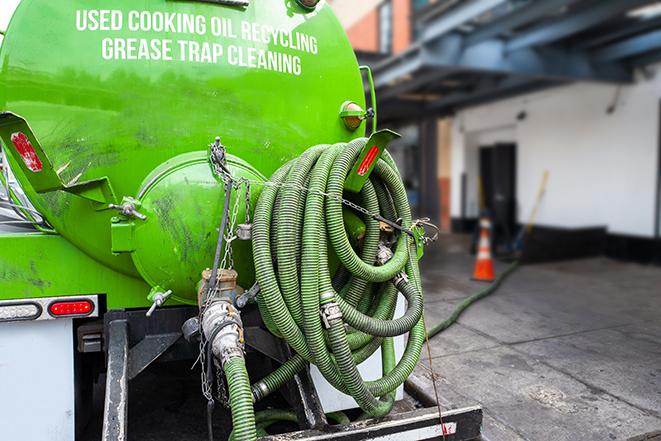 a technician pumping a grease trap in a commercial building in North Hills